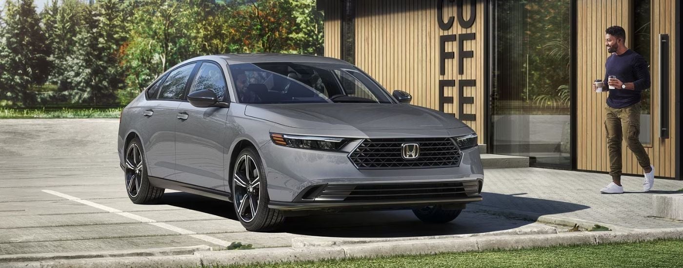 A gray 2026 Honda Accord Hybrid parked outside a coffee shop.