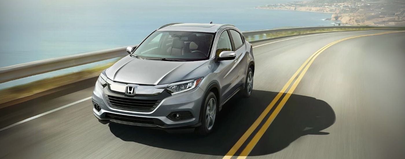 Silver 2021 Honda HR-V driving down an open road.