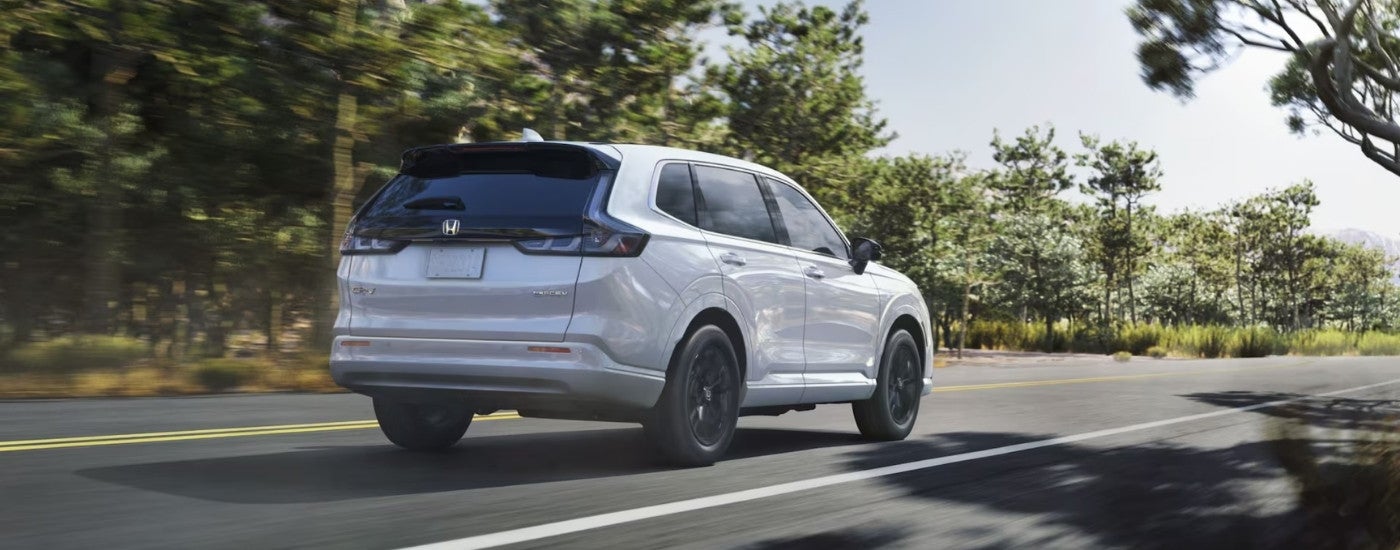 A white 2025 Honda CR-V eFCEV driving down an open road