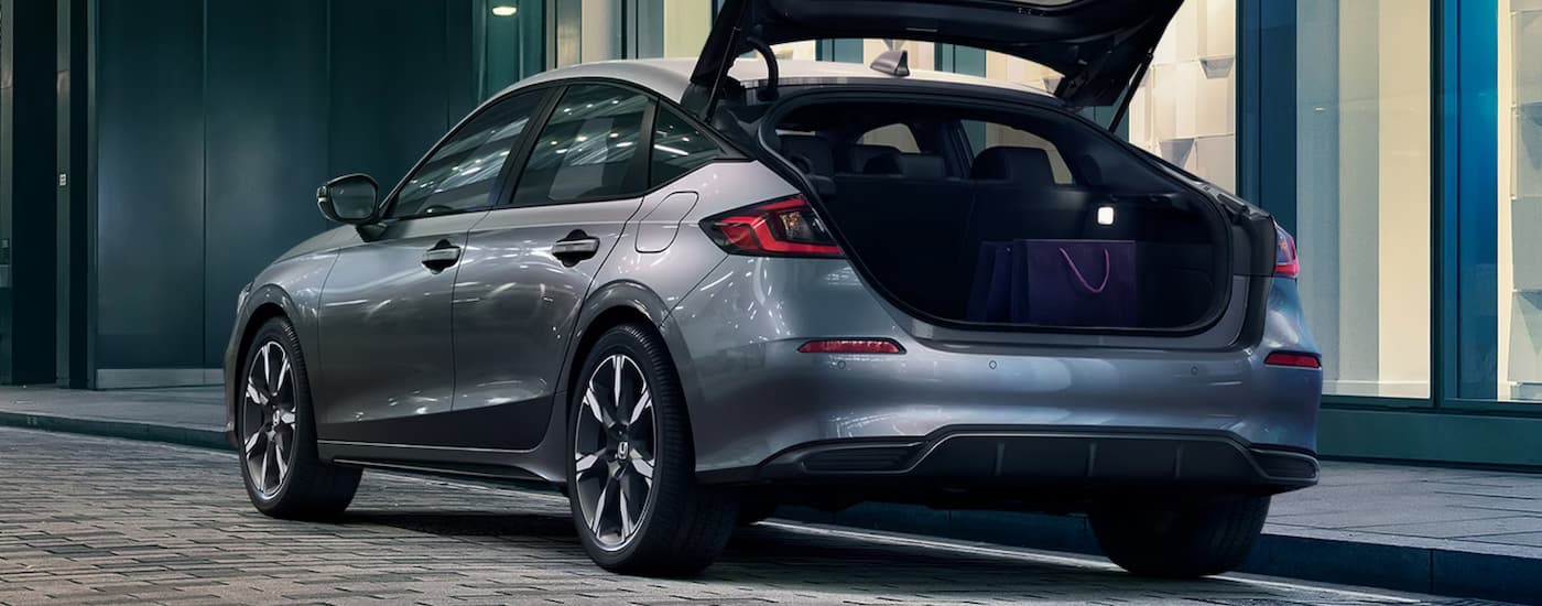 Rear of a grey 2026 Honda Civic Hatchback with an open hatch.