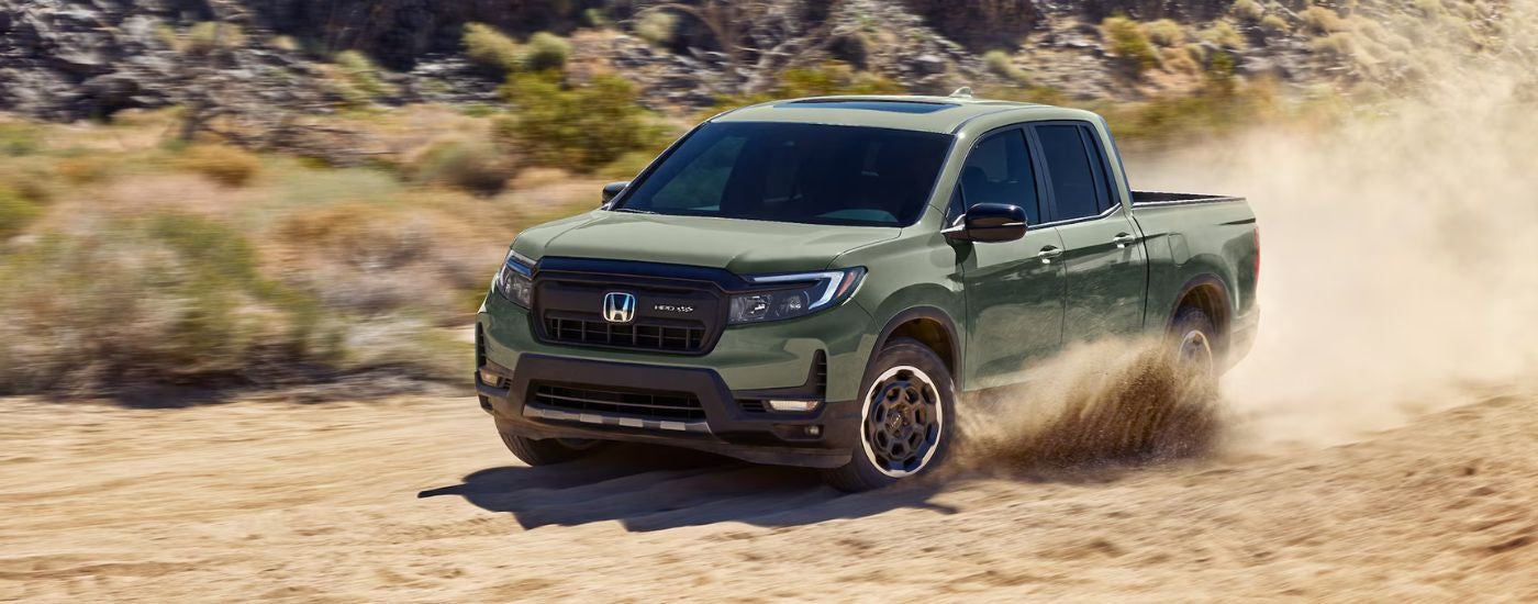 Green 2026 Honda Ridgeline HPD driving off-road in the sand.