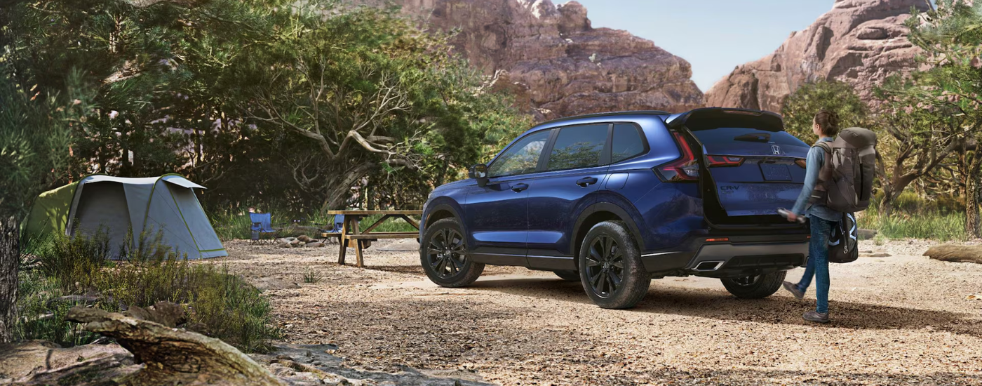 A person utilizing the foot-assisted trunk on a blue 2026 Honda CR-V