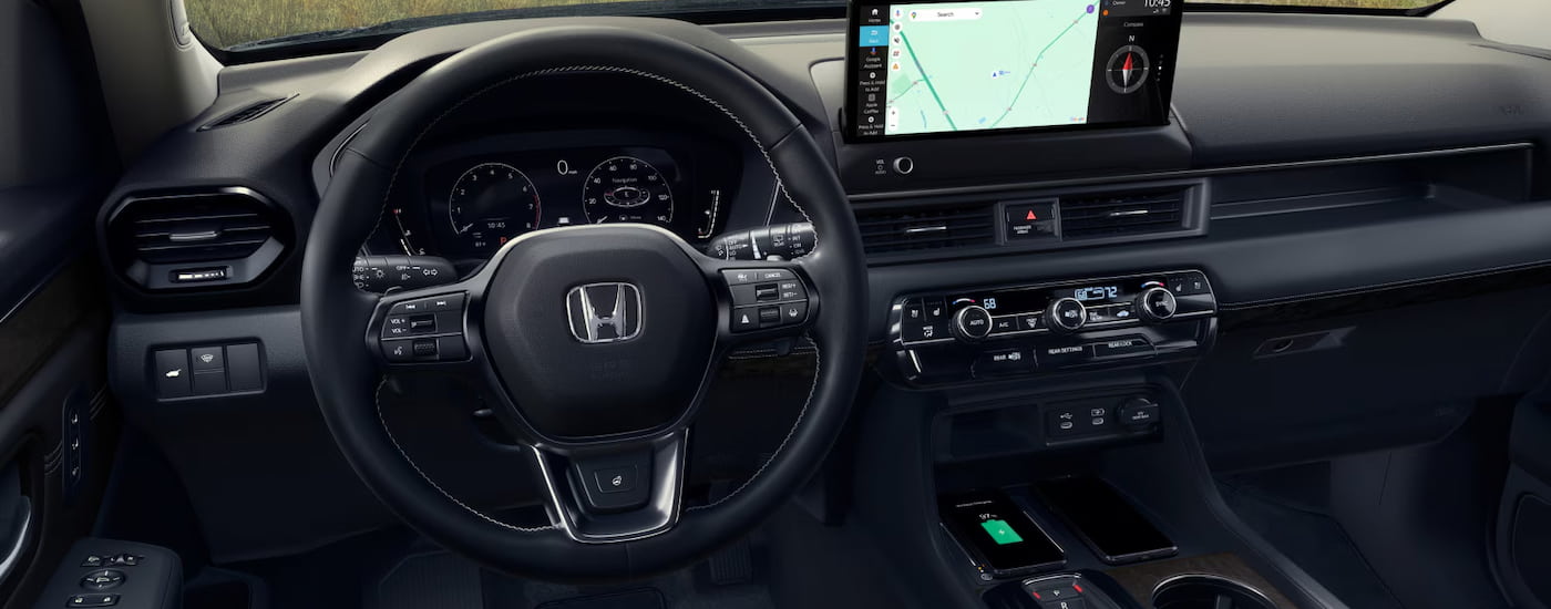 Steering wheel and dashboard in the interior of a 2025 Honda Pilot.