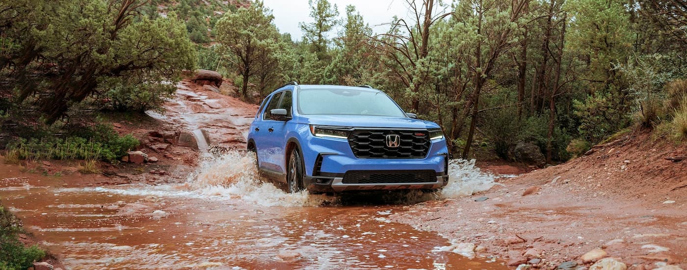 Blue 2025 Honda Pilot driving off-road.