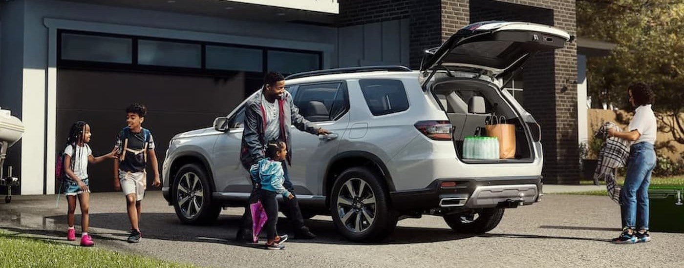 A white 2025 Honda Pilot parked on a driveway.