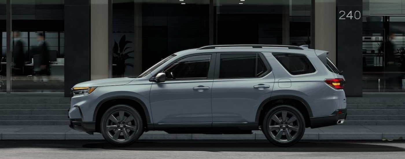 A gray 2025 Honda Pilot parked in a city.