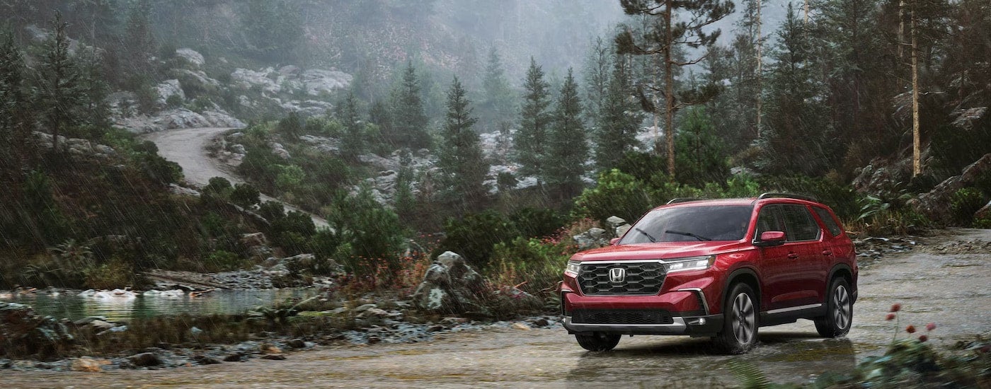 A red 2025 Honda Pilot for sale from the front.