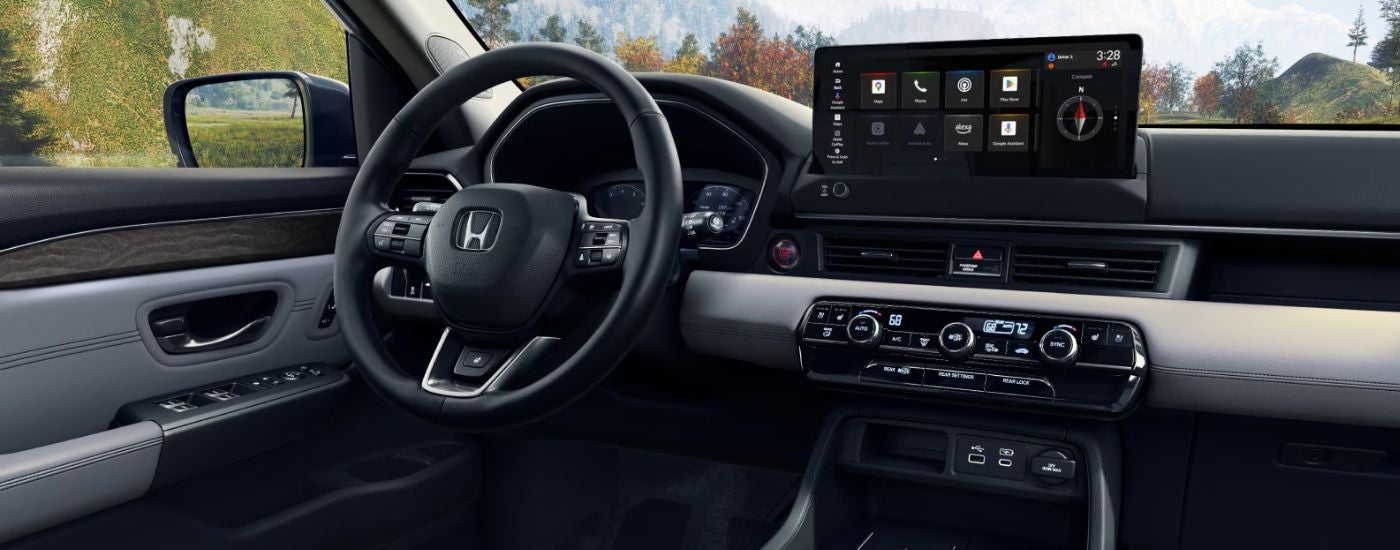 Interior view of a 2026 Honda Pilot infotainment display and steering wheel.