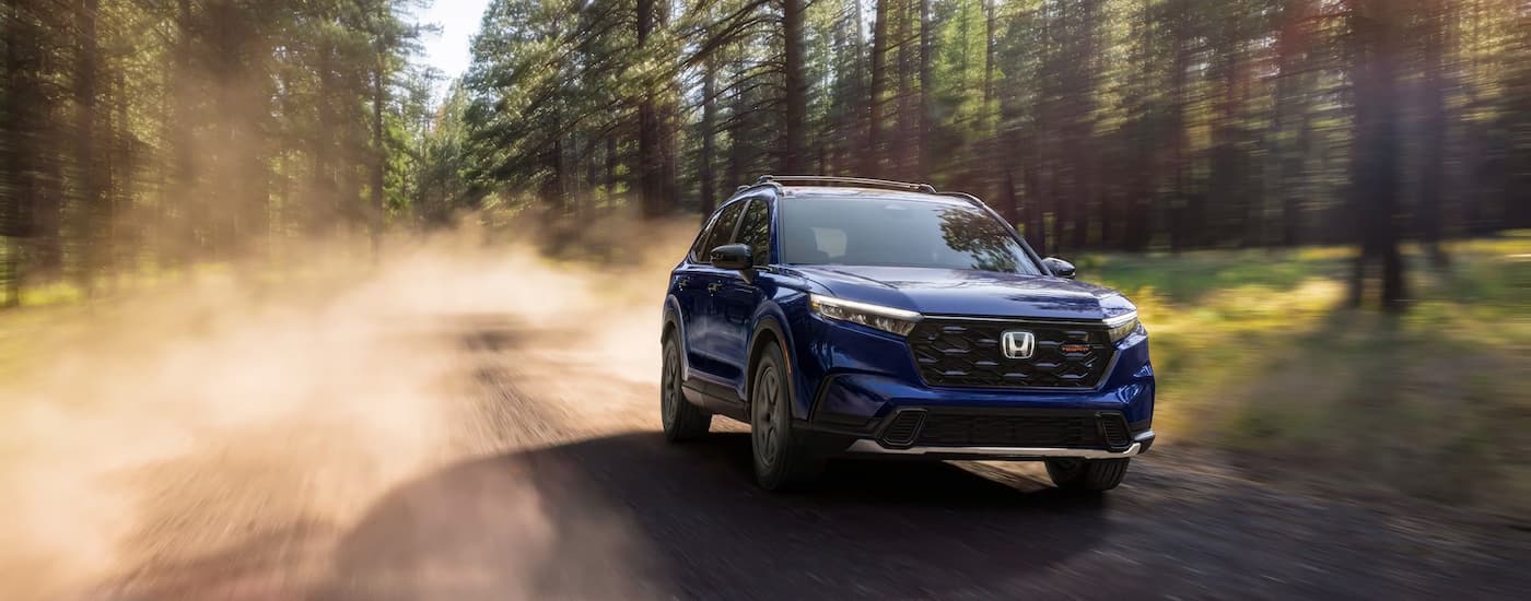 A blue 2026 Honda CR-V off-roading down a dirt trail